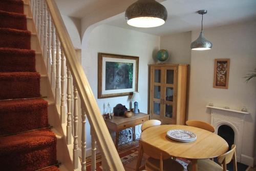 ein Esszimmer mit einem Tisch und einer Treppe in der Unterkunft The Hideout - Top of the Town - Apartment in Stroud in Stroud