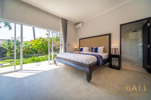 ein Schlafzimmer mit einem Bett und einem großen Fenster in der Unterkunft Villa Akasa Segara Beachfront and Private Pool in Banjar