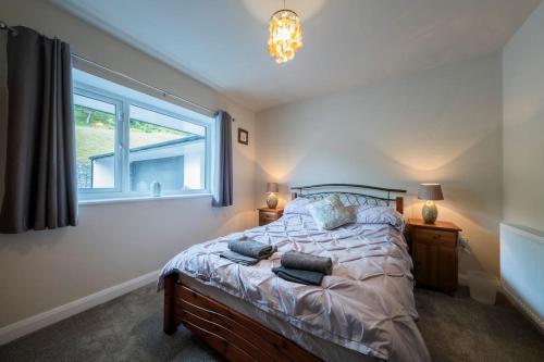 a bedroom with a large bed and a window at Five Acres - Bwnthyn Ar Y Tir in Conwy