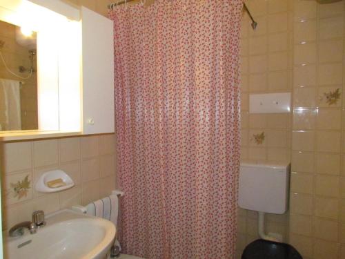 een badkamer met een douchegordijn en een wastafel bij Appartamento Xibana in Bibione
