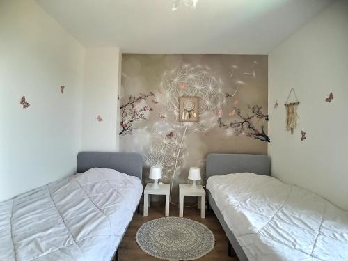 1 Schlafzimmer mit 2 Betten und Wandbild in der Unterkunft Détente, confort et sérénité, aux portes de Genève in Collonges