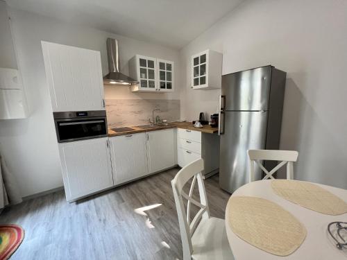 a kitchen with white cabinets and a stainless steel refrigerator at Hotel Majestic in Nîmes