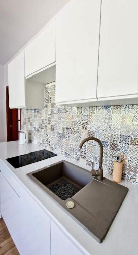a white kitchen with a sink and white cabinets at Apartamenty Harnaś in Rytro