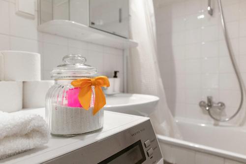 a bathroom with a mason jar with a bow in it at Gasometer Apartment - Designer Building with Amazing View in Vienna
