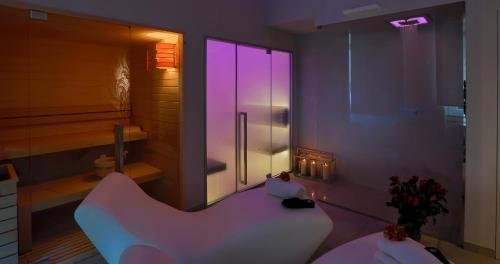 a bathroom with a white couch and a glass door at Hotel Tigullio Et De Milan in Santa Margherita Ligure