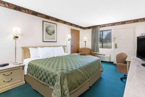 una camera d'albergo con letto e TV di Days Inn by Wyndham Concordia a Concordia