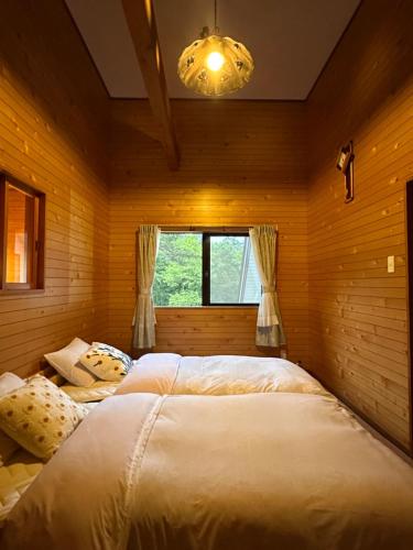 a bedroom with two beds in a room with a window at FLYING HOUSE in Chikuni