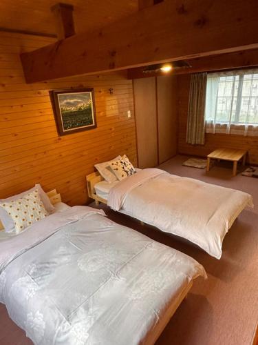 a bedroom with two beds in a cabin at FLYING HOUSE in Chikuni