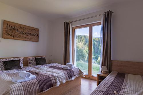 a bedroom with a bed and a large window at Apartmán Jesienka, Hillside in Dolný Kubín
