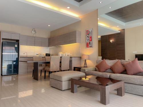a living room and kitchen with a couch and a table at Feel Like Home Pool Villa Pattaya in Jomtien Beach