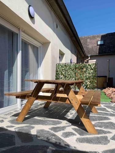 a wooden picnic table and bench in front of a building at Studio ludique campagnard (classé 3*) in Petersbach