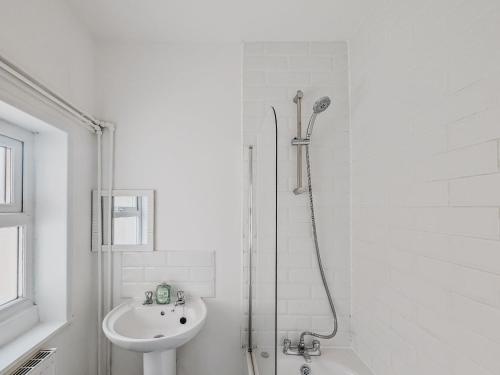 a white bathroom with a shower and a sink at Bentley House - By Sigma Stays in Crewe