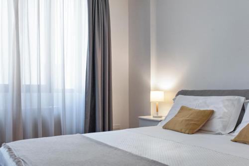 1 dormitorio con 1 cama blanca y ventana en Suite San Biagio, en Lecce