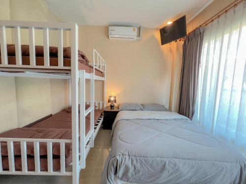 a bedroom with two beds and a bunk bed at Feel Like Home Pool Villa Pattaya in Jomtien Beach