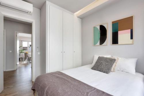Dormitorio blanco con cama y pasillo en Lisbon Central Apartment with Balcony, en Lisboa