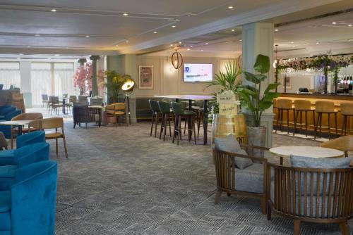 um restaurante com mesas e cadeiras e um bar em DoubleTree by Hilton Southampton em Southampton