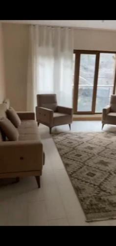 sala de estar con sofá, sillas y ventana en شقة فى طربزون, en Yomra