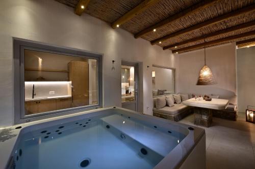 VLIA Mykonos في كالافاتيس: حمام مع حوض كبير في الغرفة