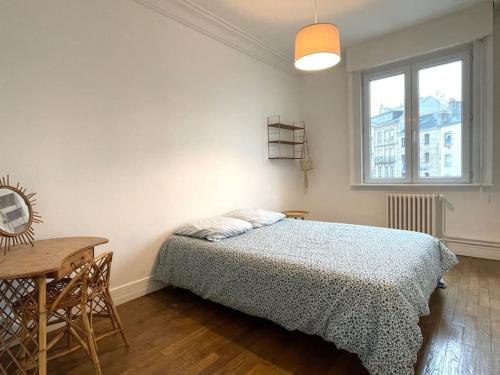 - une chambre avec un lit, une table et une fenêtre dans l'établissement La Turenne ! Hypercentre, à Lorient