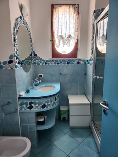 a blue bathroom with a sink and a toilet at Margiolà Amalfi in Amalfi