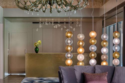 a living room with a couch and a chandelier at Hyatt Centric Murano Venice in Murano