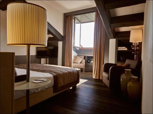 a hotel room with a bed and a table with a lamp at Hyatt Centric Murano Venice in Murano
