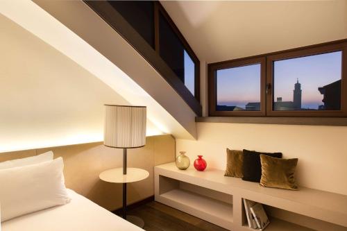 a bedroom with a bed and a window at Hyatt Centric Murano Venice in Murano