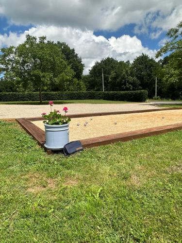 un planteur avec une fleur sur un banc dans l'établissement Luxury 3 Bed Home with Heated Swimming Pool Air Con and Boules Pitch, à Salignac