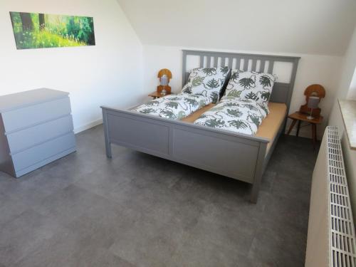 een slaapkamer met een bed en een dressoir bij Haus Reger in Krummhörn