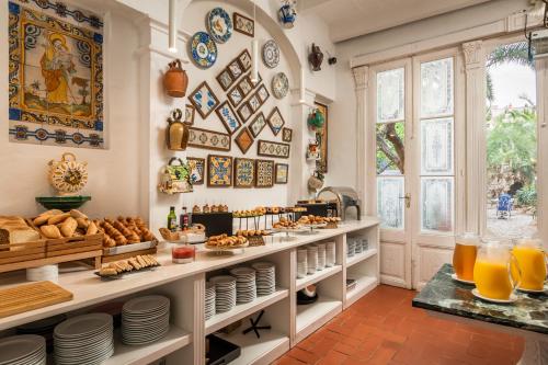 a breakfast room with bread and orange juice at Hotel Medium Sitges 1883 in Sitges