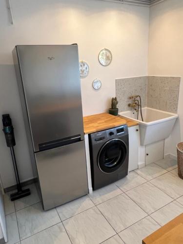 une cuisine avec un réfrigérateur et une machine à laver dans l'établissement Belle villa typique du sud avec grande piscine, à Assas