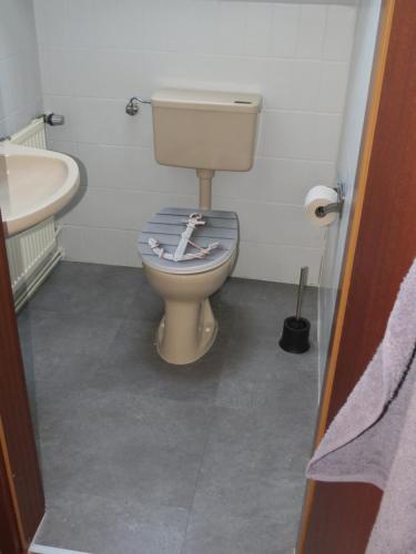 a bathroom with a toilet and a sink at Ferienhaus PH 17 in Krummhörn