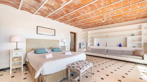 a bedroom with a large bed and a bench at Can Anadï in Sant Jordi