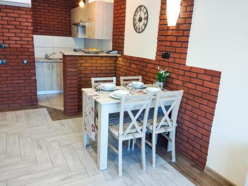 a kitchen with a table with chairs and a brick wall at Willa STRITZKI in Wisła