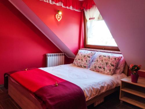 a bedroom with red walls and a bed with a window at Willa STRITZKI in Wisła
