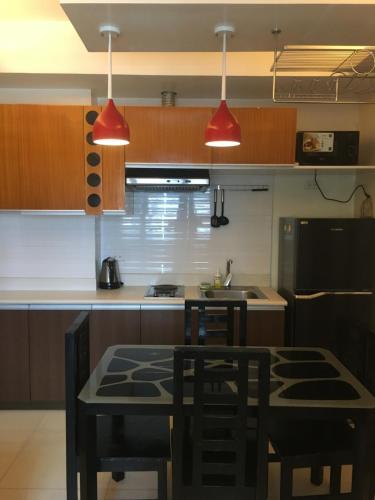 a kitchen with two red lights above a table at 1 Bedroom US Embassy Roxas Blvd. Ermita Manila in Manila