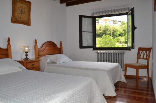 1 Schlafzimmer mit 2 Betten, einem Fenster und einem Stuhl in der Unterkunft Casa Fidel in Fontanina