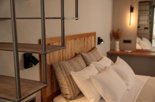 a bedroom with a bed with white pillows at "Makava Suites" Your Luxe Urban Sanctuary in Naxos Chora