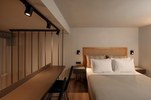 a bedroom with a bed and a desk with a chair at "Makava Suites" Your Luxe Urban Sanctuary in Naxos Chora