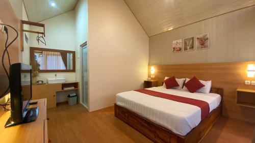 une chambre d'hôtel avec un lit et une télévision dans l'établissement Rautani Sembalun, à Sembalun Lawang