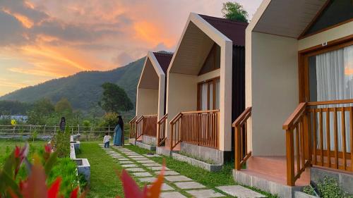 a row of houses with a sunset in the background at Rautani Sembalun in Sembalun Lawang