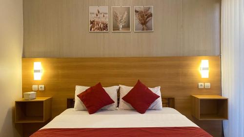 a bedroom with a bed with red and white pillows at Rautani Sembalun in Sembalun Lawang