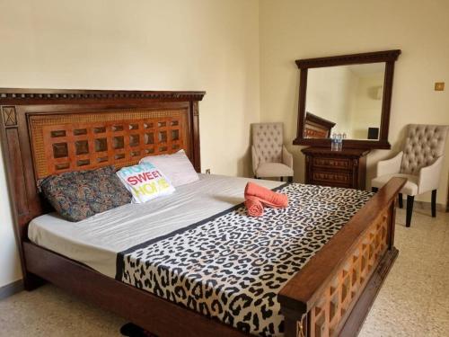 a bedroom with a large bed with a leopard print sheets at VictoriaS in Al Ain