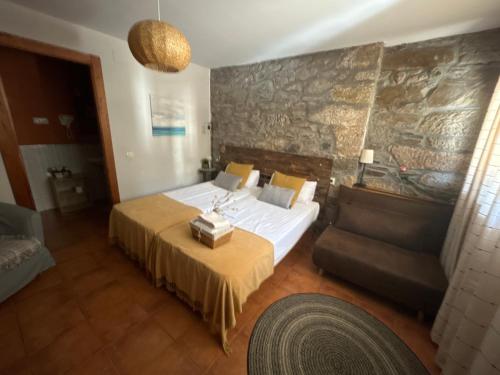 1 dormitorio con 1 cama y 1 sofá en Hostal Casa San Nicolas, en Molinaseca