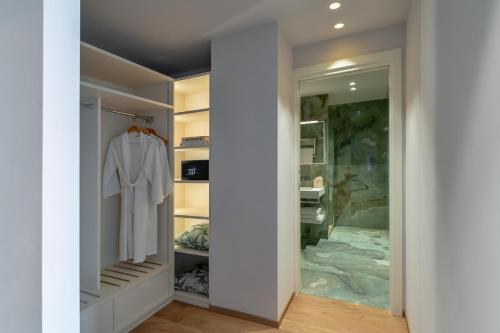 a walk in closet with a white robe in it at Olivi Hotel & Natural Spa in Sirmione