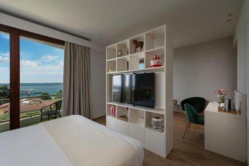 a hotel room with a bed and a large window at Olivi Hotel & Natural Spa in Sirmione