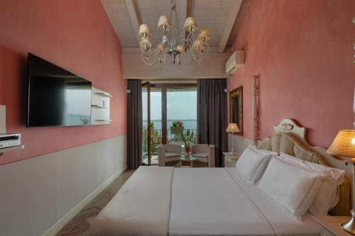 a bedroom with a large white bed and a chandelier at Olivi Hotel & Natural Spa in Sirmione