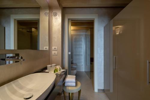 a bathroom with a large tub and a sink at Olivi Hotel & Natural Spa in Sirmione