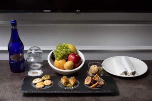 a tray with a bowl of fruit and a plate of food at Mula Hotel in Istanbul