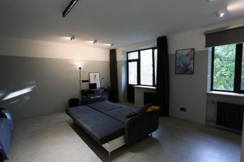 sala de estar con sofá azul y ventanas en City center modern appartment, en Odessa